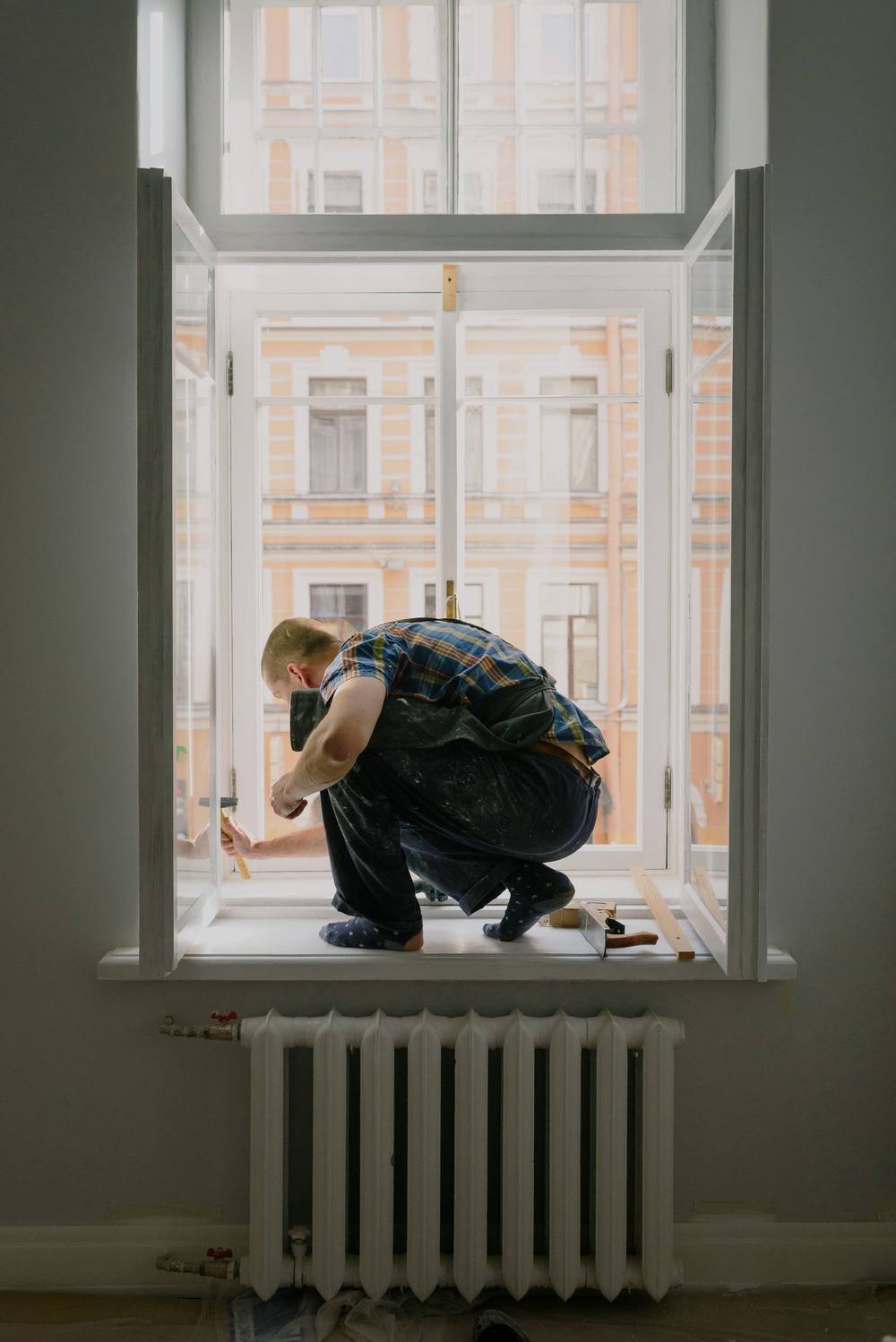 Worker repairing a window frame